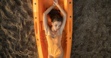 woman in yellow swimsuit lying on orange inflatable bed